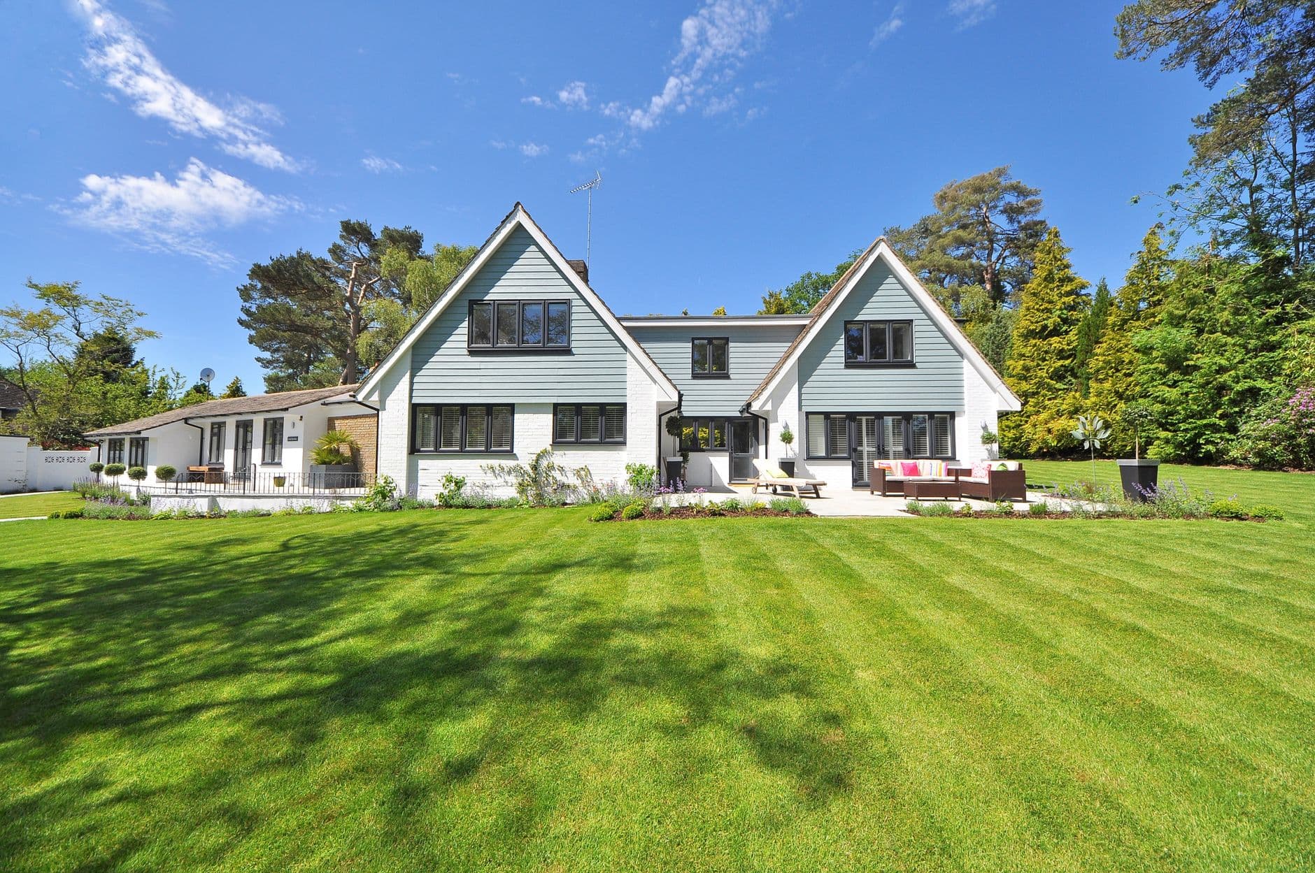 A freshly mown green lawn in front of a suburban house in warm afternoon light